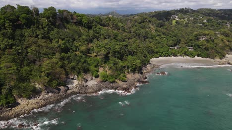 drone shot flying over turquoise water towards the coast, manuel antonio, costa rica