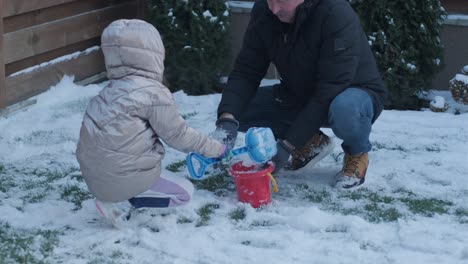 grandfather and granddaughter having fun in the snow