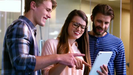 Lächelnde-Kollegen-Diskutieren-über-Das-Digitale-Tablet-Im-Büro