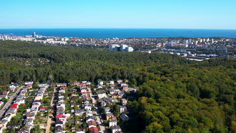 Aerial-reverse-dolly-above-suburban-neighborhood-by-the-sea,-space-for-text