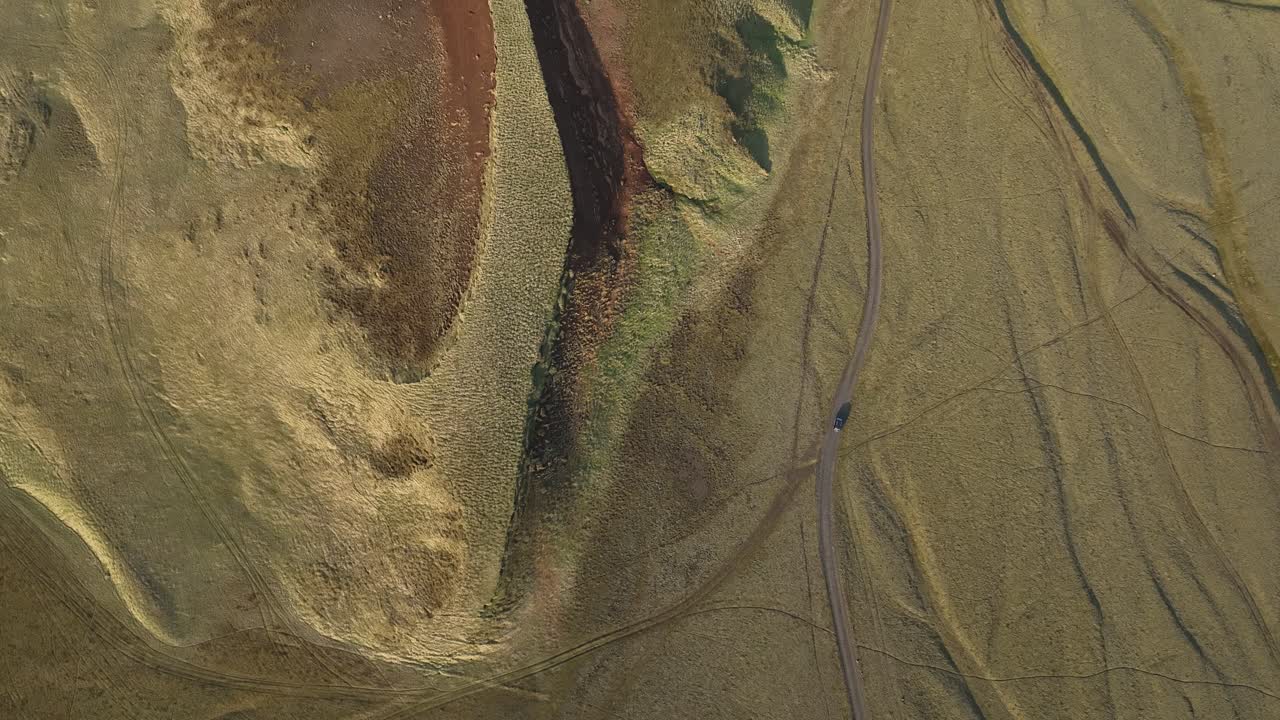 Aerial View of a Remote Grassland with a Car on a Dirt Road