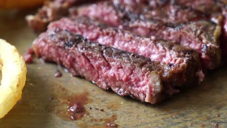 bistec de ternera en rodajas sobre tabla de madera