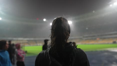 woman at a rainy night football game