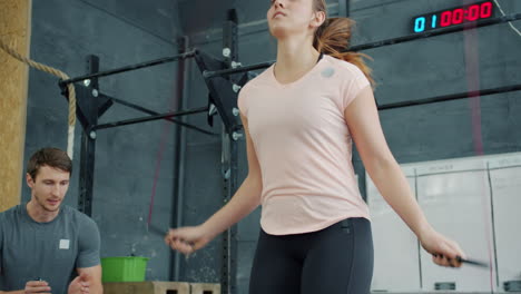 Woman Jumping Rope with Trainer in Gym