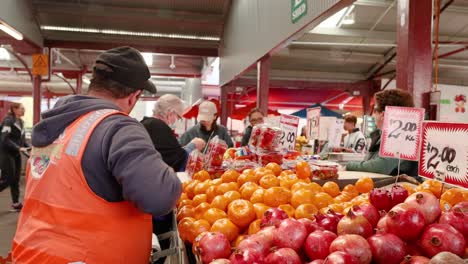 man arranging mandarins at a fruit market