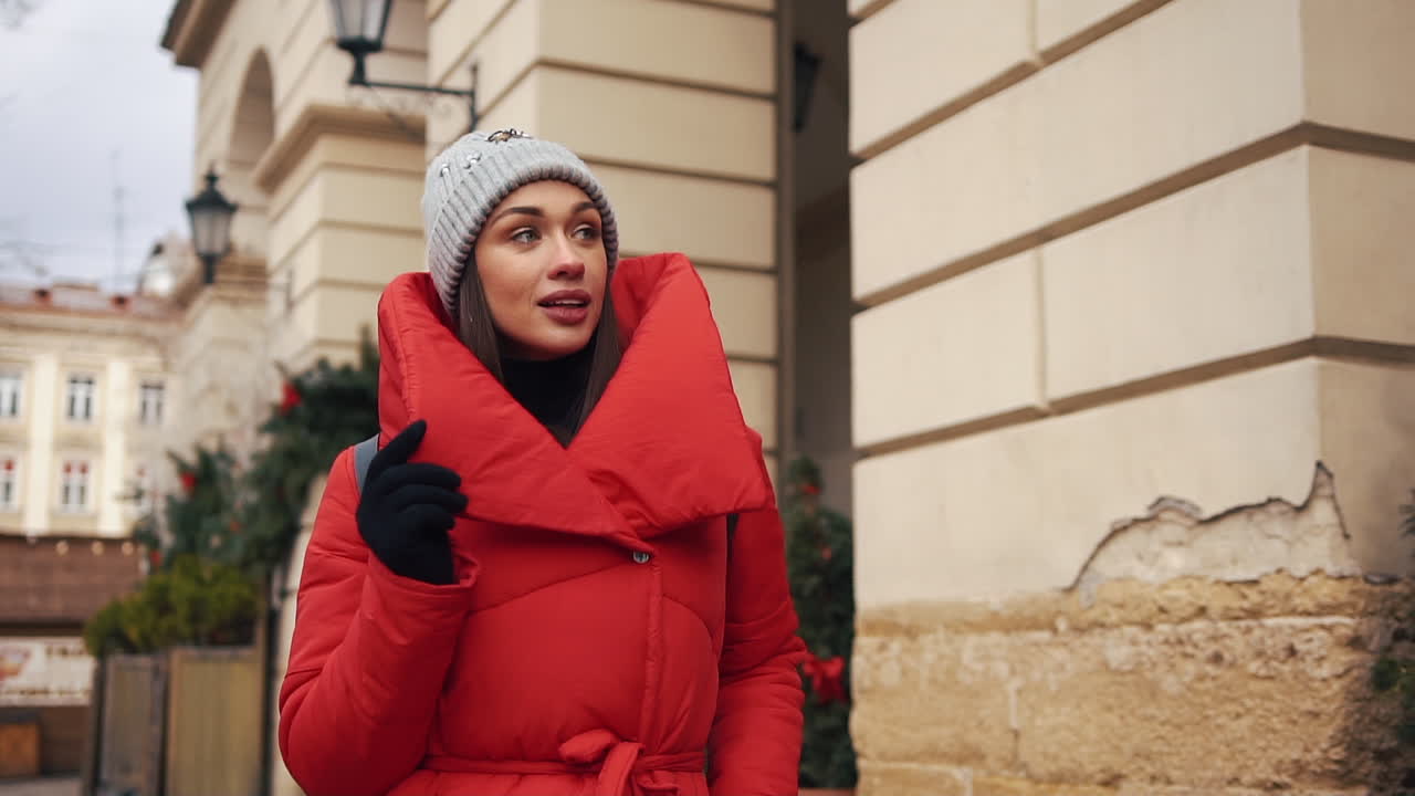 Woman in red winter coat and beanie