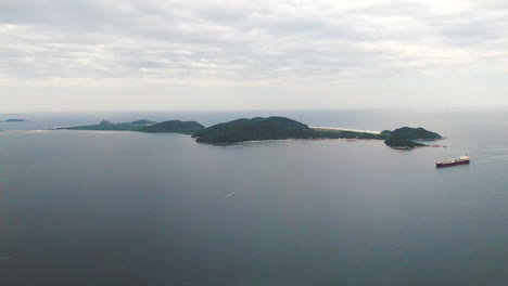 Aerial-landscape-of-Ilha-do-Mel,-cargo-ship-sailing-in-Paranagua-Bay,-Paraná,-Brazil