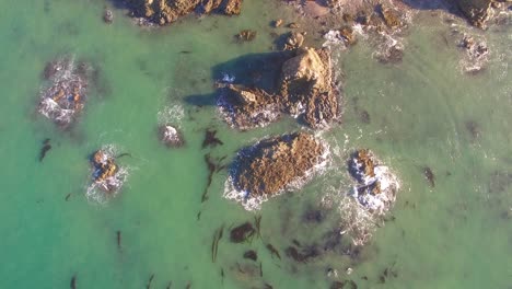 Vista-Aérea-De-Las-Olas-Del-Océano-Chocando-Contra-Las-Rocas.