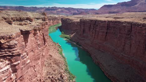 slow tilting up shot of the colorado river through a narrow desert canyon