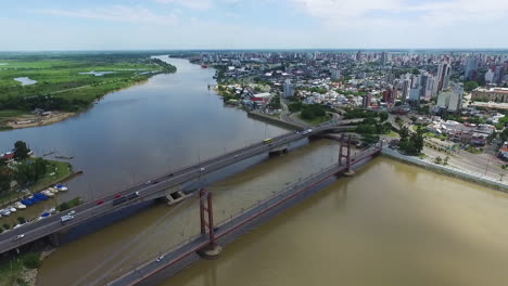 vista aérea estática del tráfico en puentes sobre el río santa fe, argentina, frente al mar y paisaje urbano en un día soleado de verano, disparo de drones