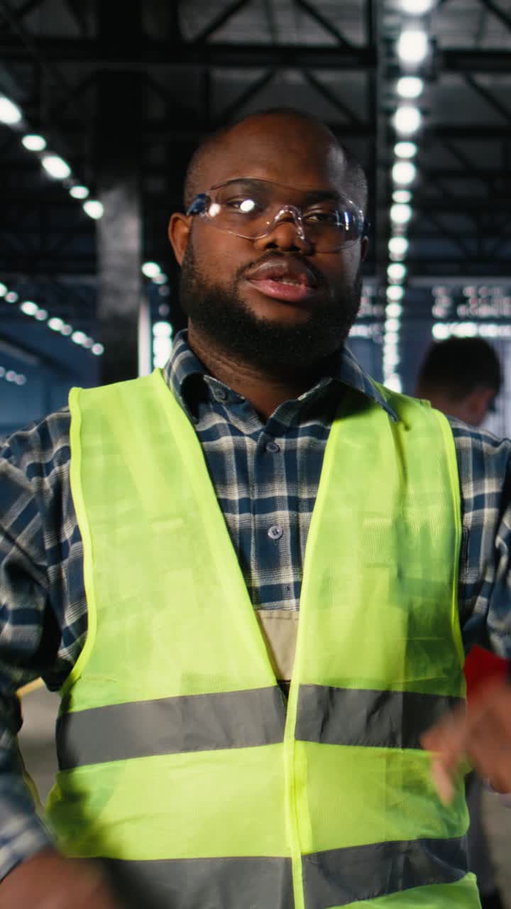 Vertical Video Engineer in safety glasses uses tools in a fabrication workshop