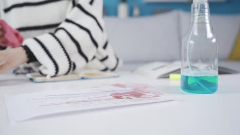 Woman-wiping-spilled-liquid-stain-on-table.-Liquid-spilled-on-the-document.