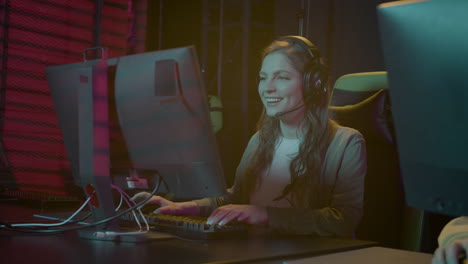 happy female gamer playing virtual video games while sitting in gaming club