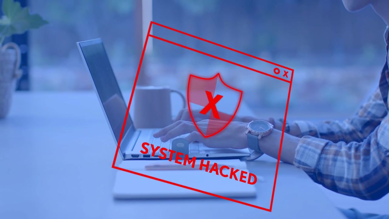 Man typing at desk, red warning tracing over laptop, glitching and revealing SYSTEM HACKED security