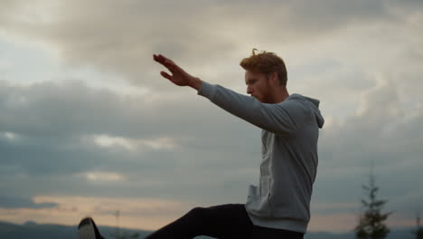 male jogger warming legs before workout. active athlete lifting legs up to hands