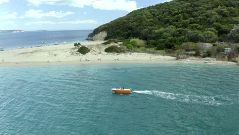 Drone-Dando-Vueltas-En-Un-Barco-Cerca-De-La-Isla-De-Marathonisi-En-Zakynthos,-Grecia