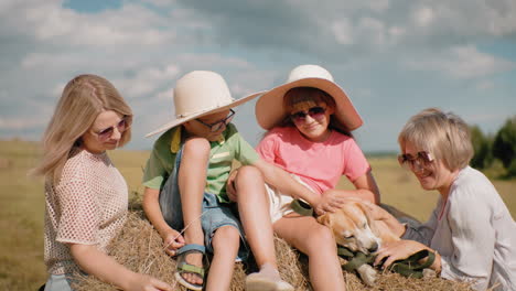 family enjoys fun on sunny day in vast farmland, children climbing hay, woman laughing in sunglasses, rolling hills and trees in background, golden grass, warm countryside