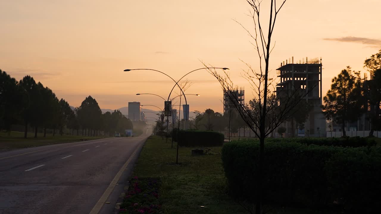 A beautiful cinematic morning view of Islamabad with a yellowish sky with sunrise and buildings under construction on Margalla Road with no people