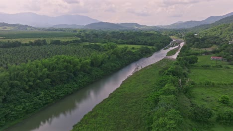 aerial flyover rio haina surrounded by deep lush green scenery in dominican republic