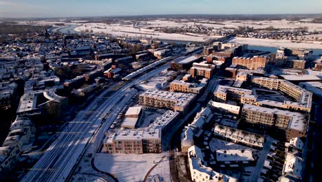 aerial descending approach of exterior facade residential housing at the ettegerpark during sunrise after a snowstorm with inclusive park covered in snow dutch real estate investment urban development