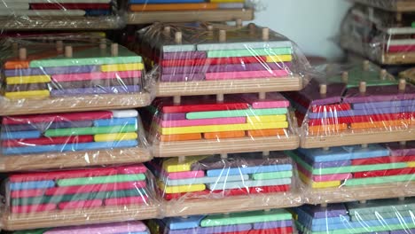 stacks of wooden puzzles and games on factory shelf, plastic wrapped for shipping