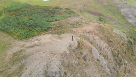 around and in front of male model in, watch point in the mountain with drone control in his hands