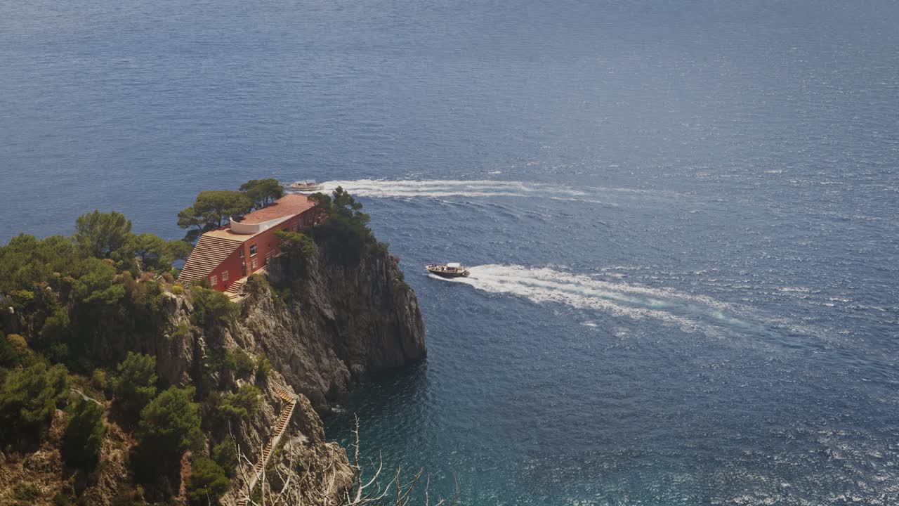 los turistas pasan en barco cerca de villa malaparte en capri durante un día soleado