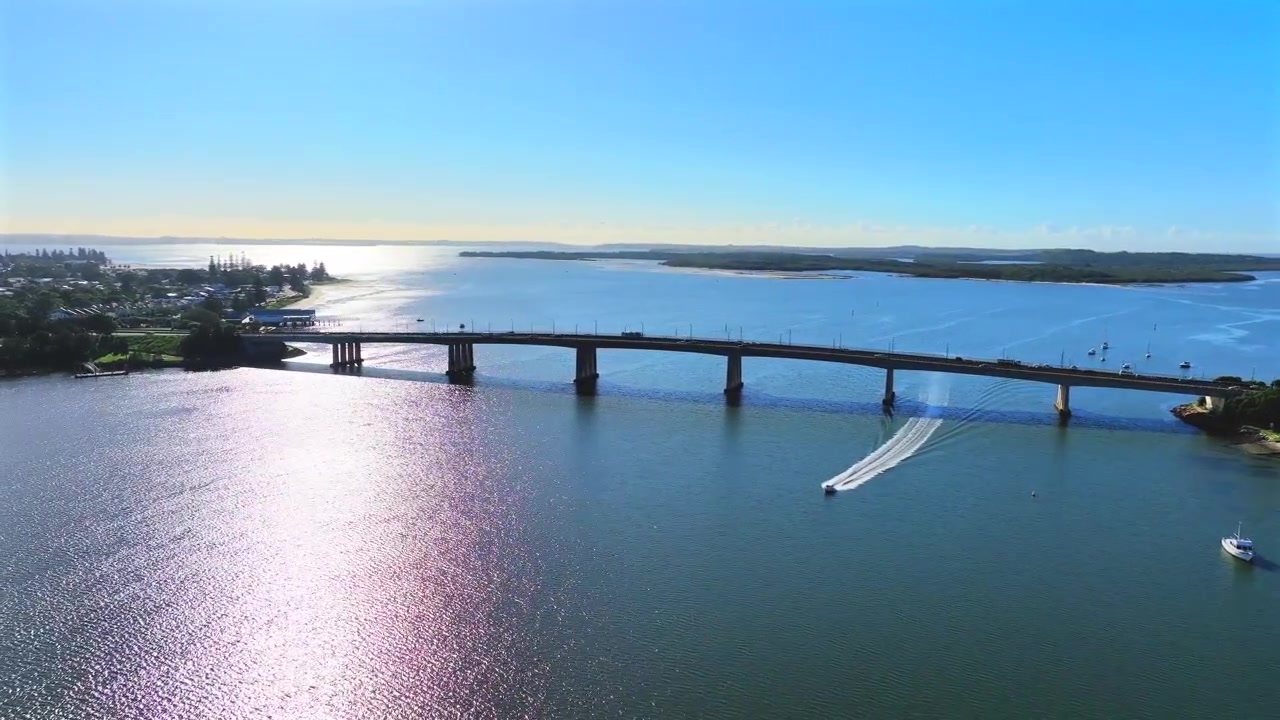 Ripresa con drone di una barca che passa sotto un grande ponte in partenza da Botany Bay, Sydney, Australia