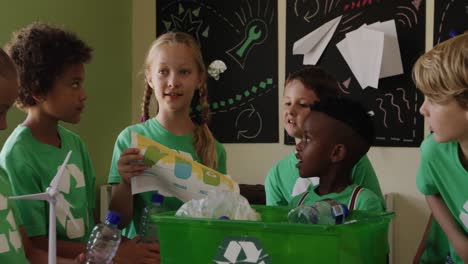 girl holding a poster about recyclable materials in the class