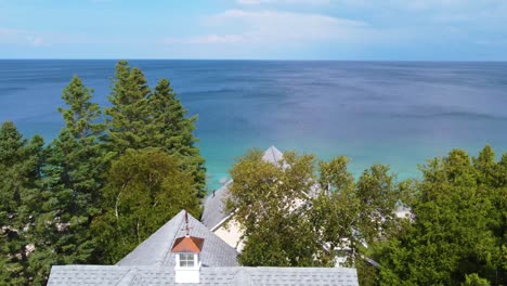 constructions and houses next to crystalline sea and green vegetation and the horizon in the background