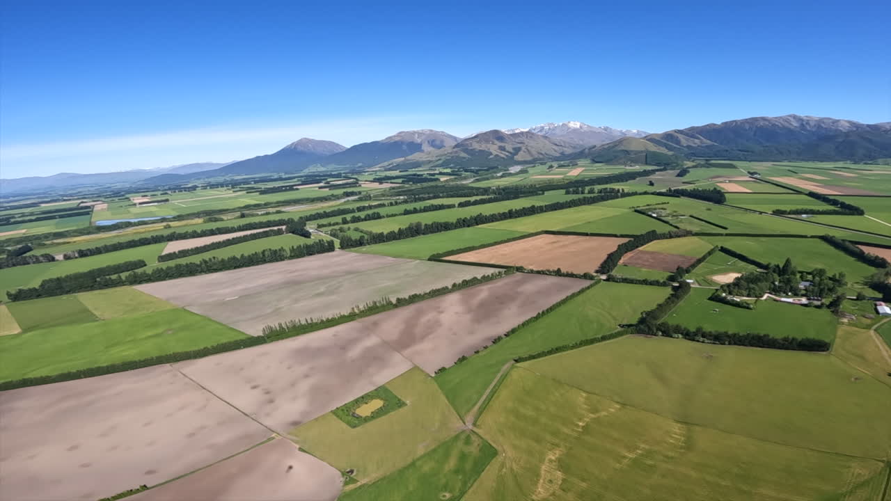 Aerial Helicopter Shot Flying Over Green Fields and Pastures Near Methven, New Zealand