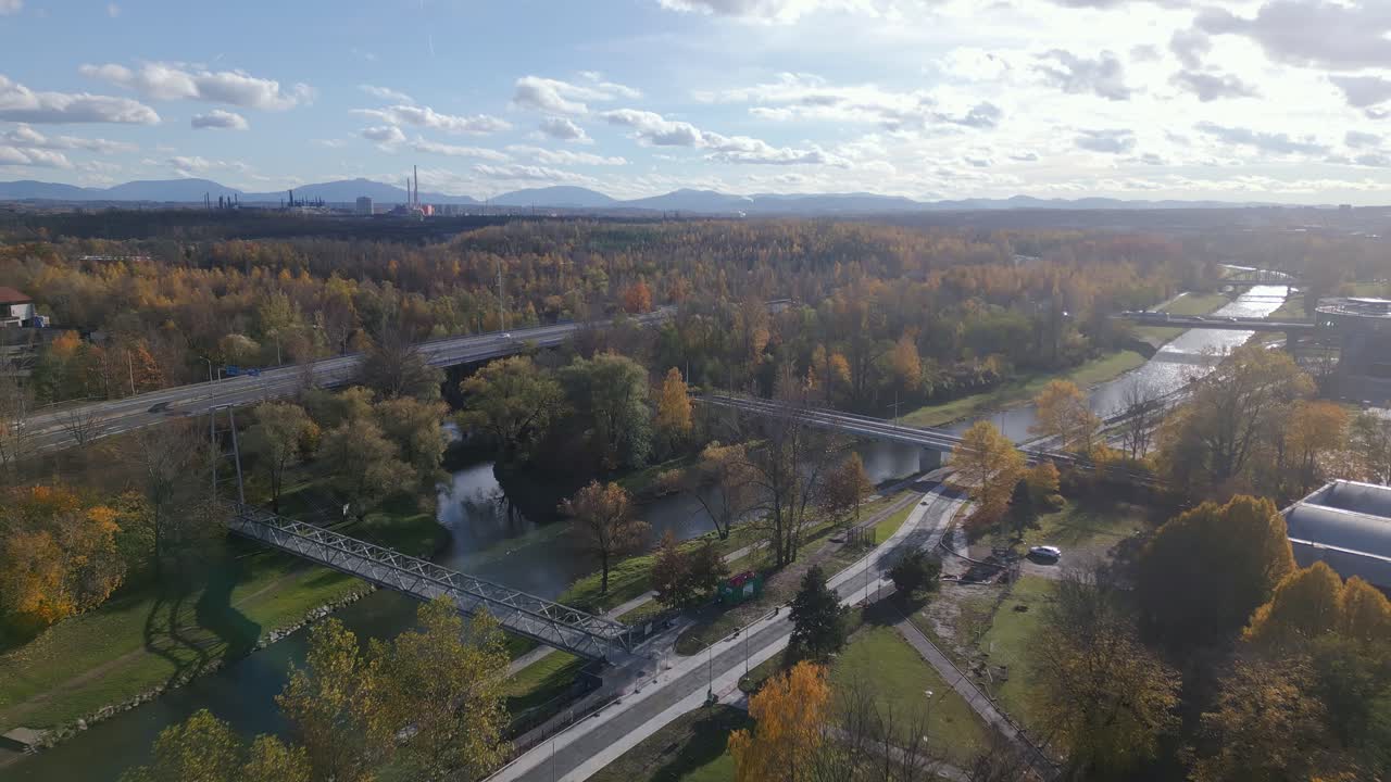 Ostravice River with steel industry skyline and autumn woodland AERIAL