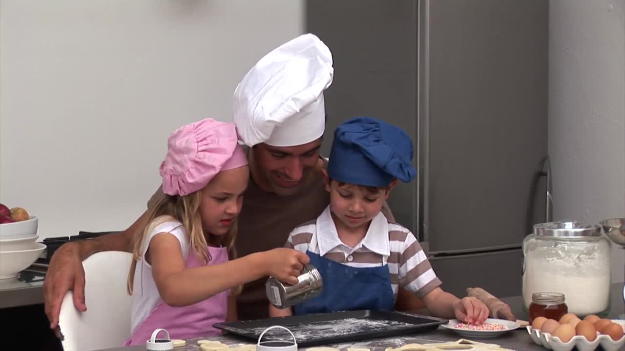 padre atractivo preparando una comida con sus hijos