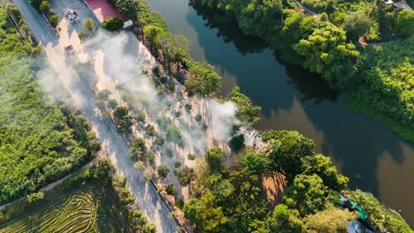 smoke rising up from a small village in the west of thailand surrounding in forests