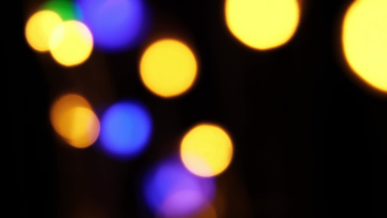 Abstract bokeh background in motion. shining, blurred multicolored particles, lights. bright bokeh from garlands on dark background. New year or Christmas festive backdrop