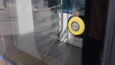 close up of a yellow door button on a public transportation vehicle