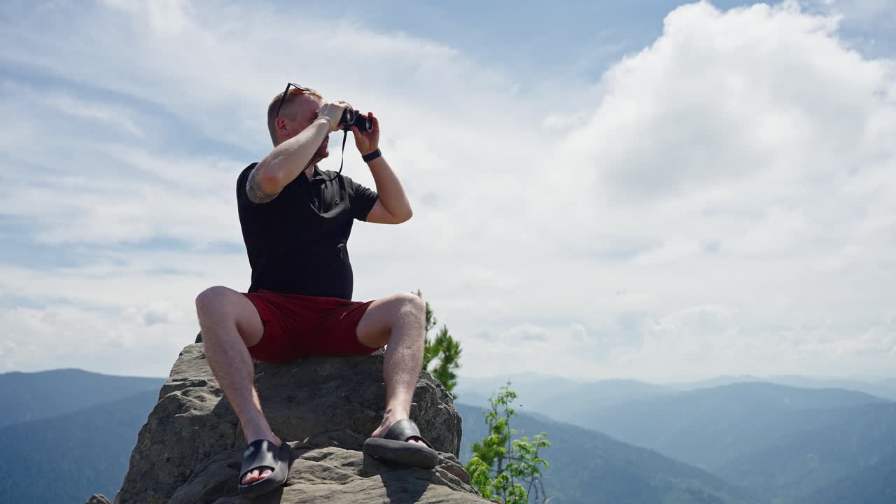 Man with Binoculars on Mountain Top