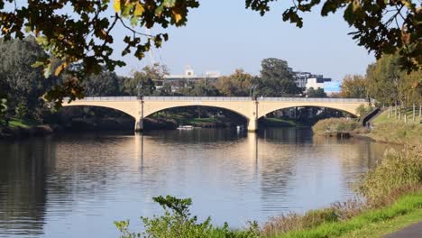 bridge over calm river with autumn leaves