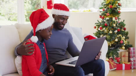 african american father and son having a videocall on laptop