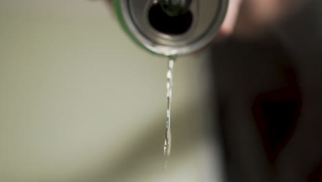 slow motion beer pouring out of can onto camera lens alcoholic quitting drinking