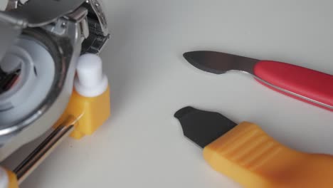 close-up of watch repair tools in use on a white table