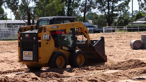 loader lifting and dumping dirt in equestrian arena