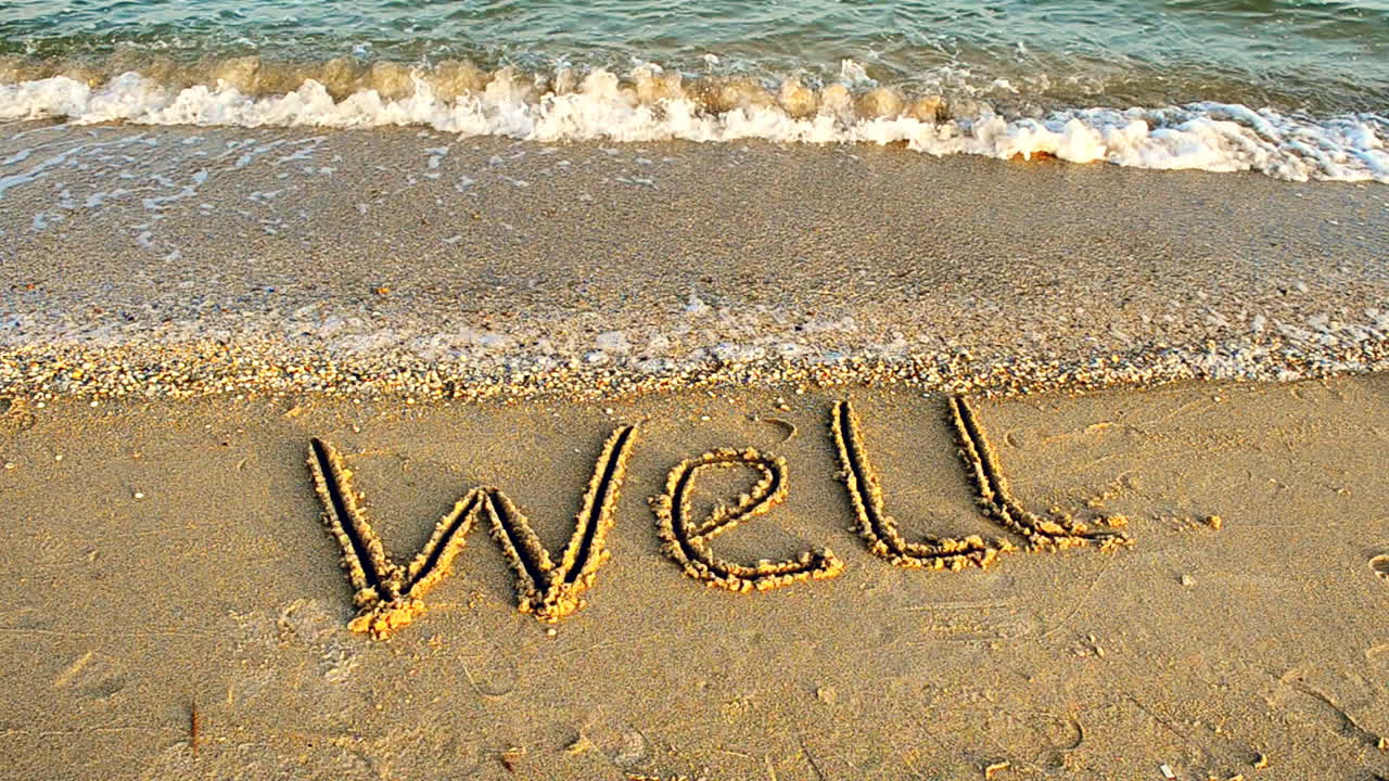 Shooting on the beach. The inscription WELL on sand