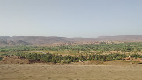 shot from a driving car of atlas mountains and desert landscape near marrakesh in morocco.