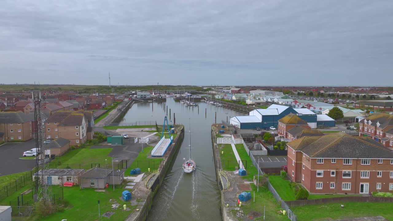yate dirigiéndose a través de un estrecho canal entrando en la marina en aguas tranquilas