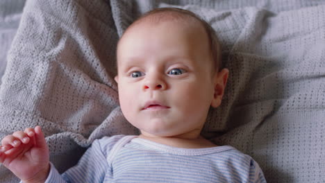 portrait happy baby looking curious infant lying on blanket