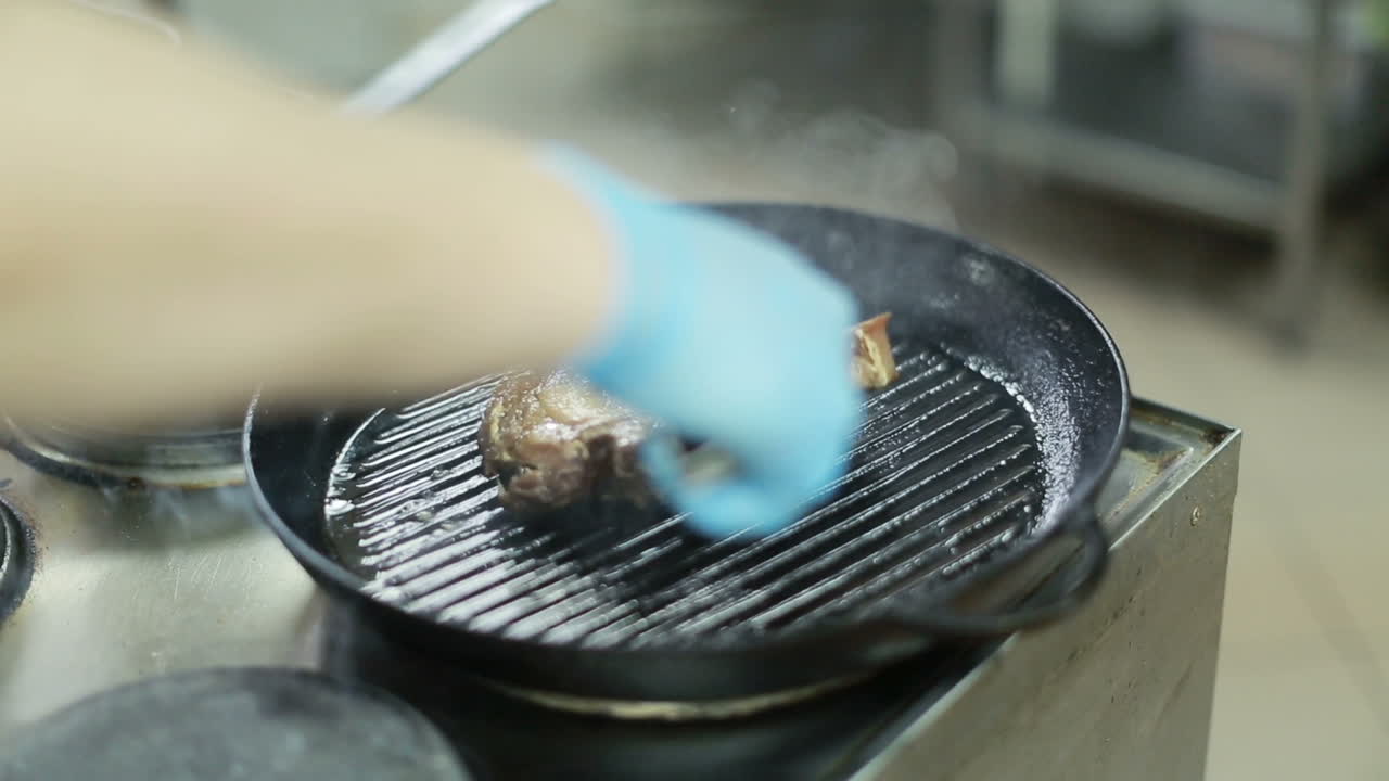 Beef Steak In A Frying Pan. Chef is preparing delicious beef steak meat on pan