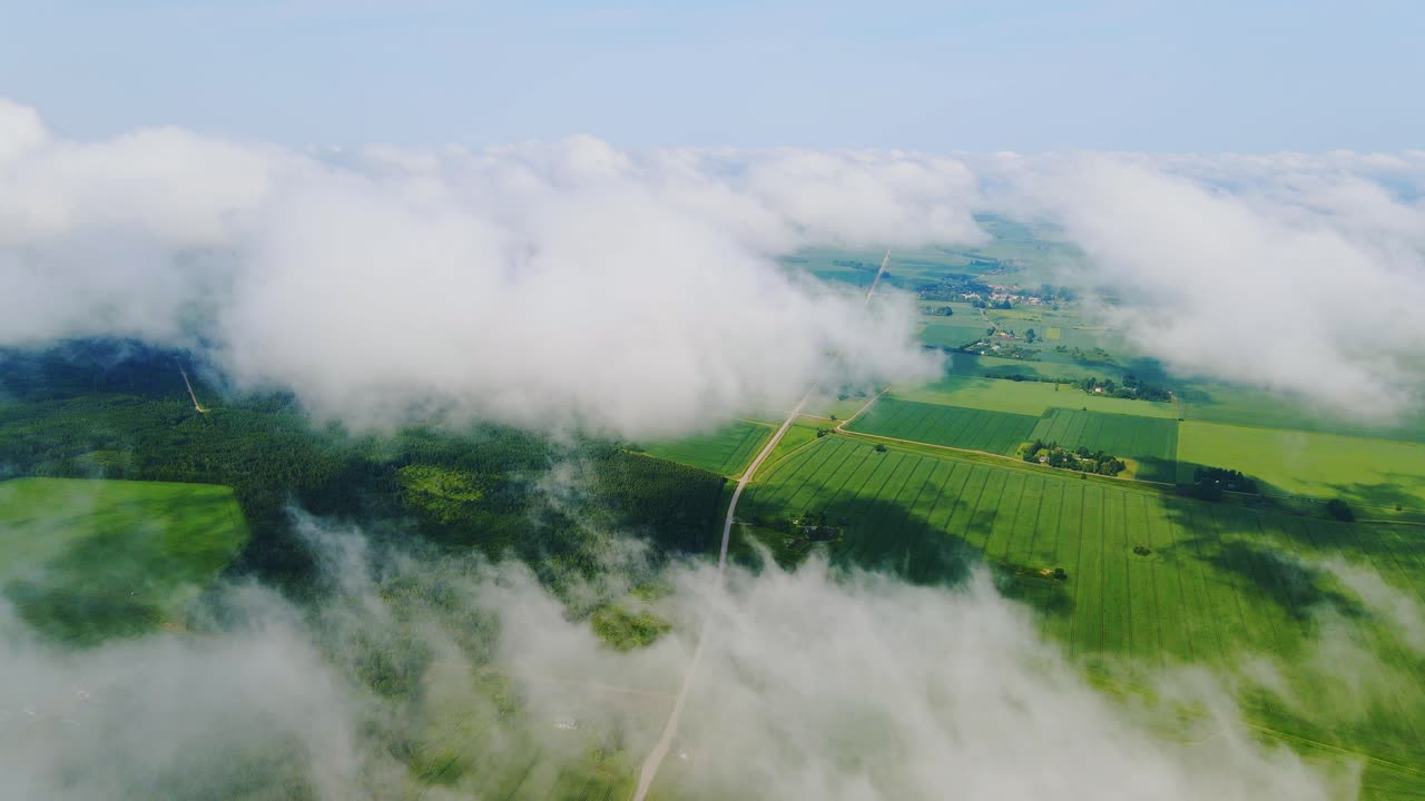 Clouds drift right over rural fields and road in static aerial timelapse view