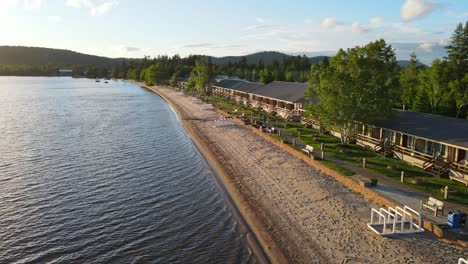 a drone shot passing the beachfront with people enjoying their evening outside of their rental houses