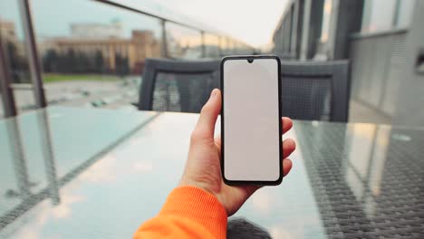 muster eines männlichen handgeräts, das ein smartphone hält